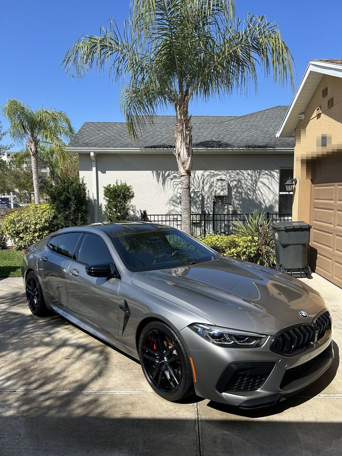 Bronze BMW M8 Competition in full sun, reflections running clean down the flank
