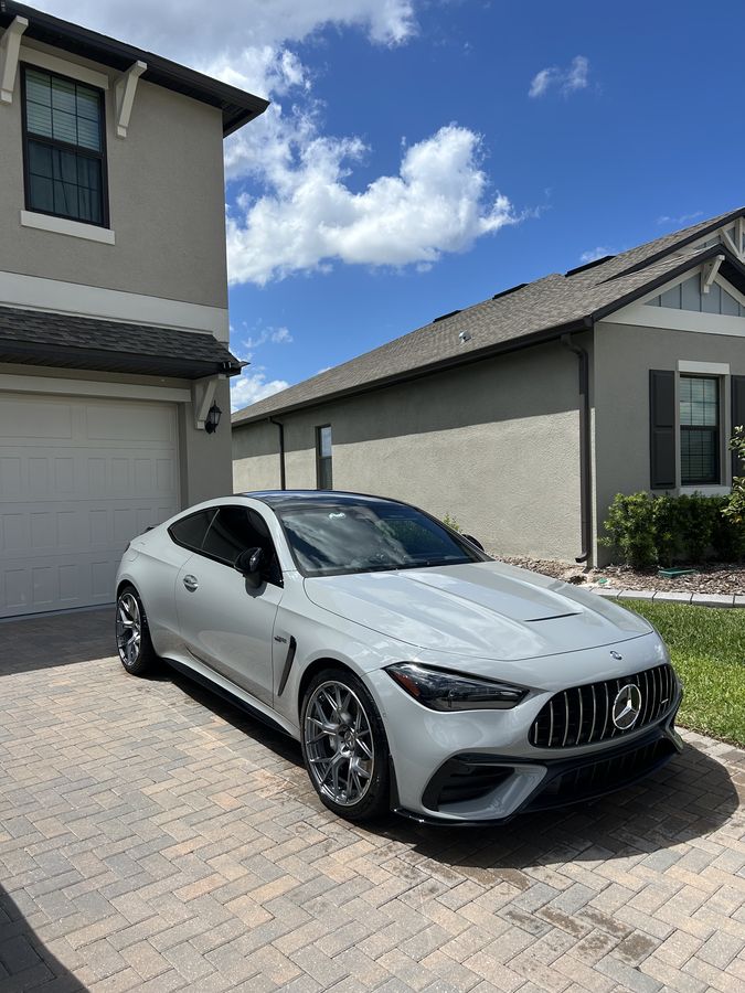 Mercedes-AMG CLE 53 coupe in light grey, sitting finished on a paver drive