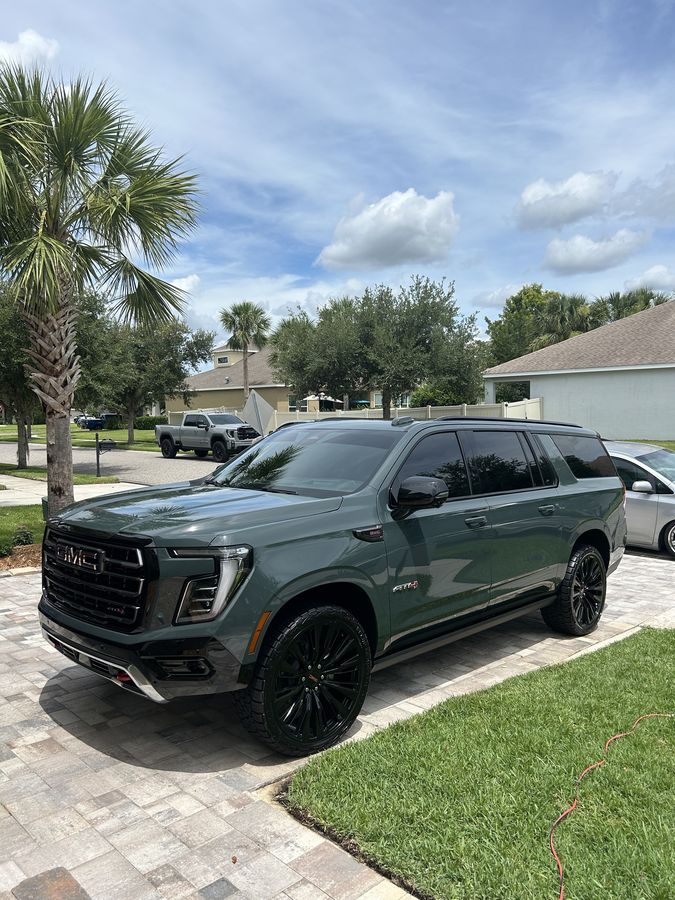 Dark green GMC Yukon XL AT4 on black wheels, glass and paint finished