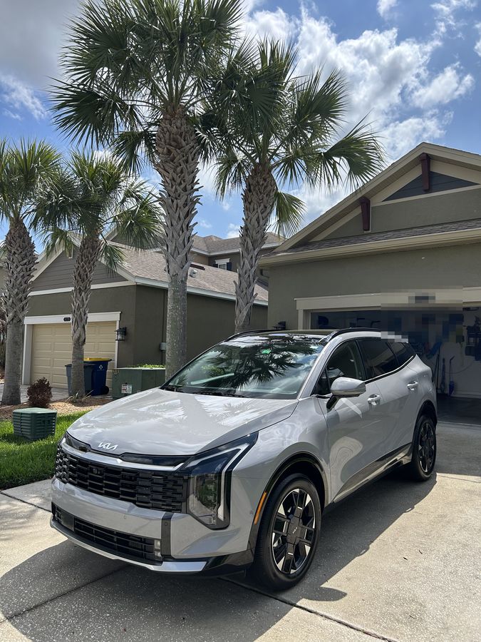 Silver Kia Sorento finished on a driveway under palms