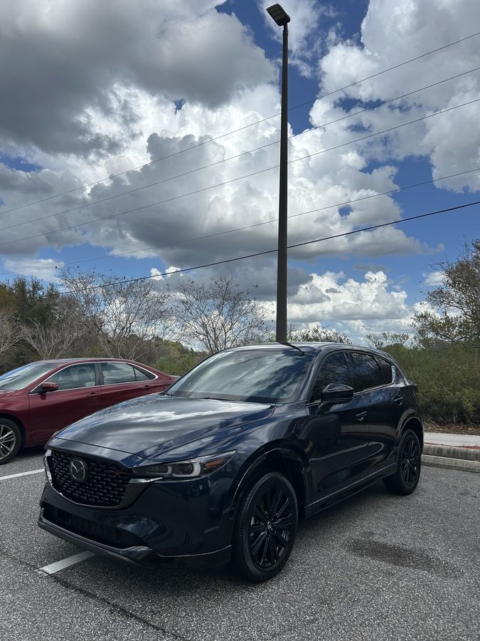 Dark grey Mazda CX-5 finished in a parking bay